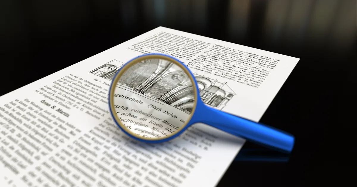 A magnifying glass held over a printed page, the magnified text in sharp focus.