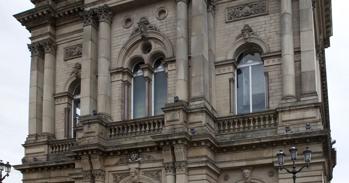 Detail of the carved stone facade of Huddersfield Town Hall, headquarters of Kirklees Council.